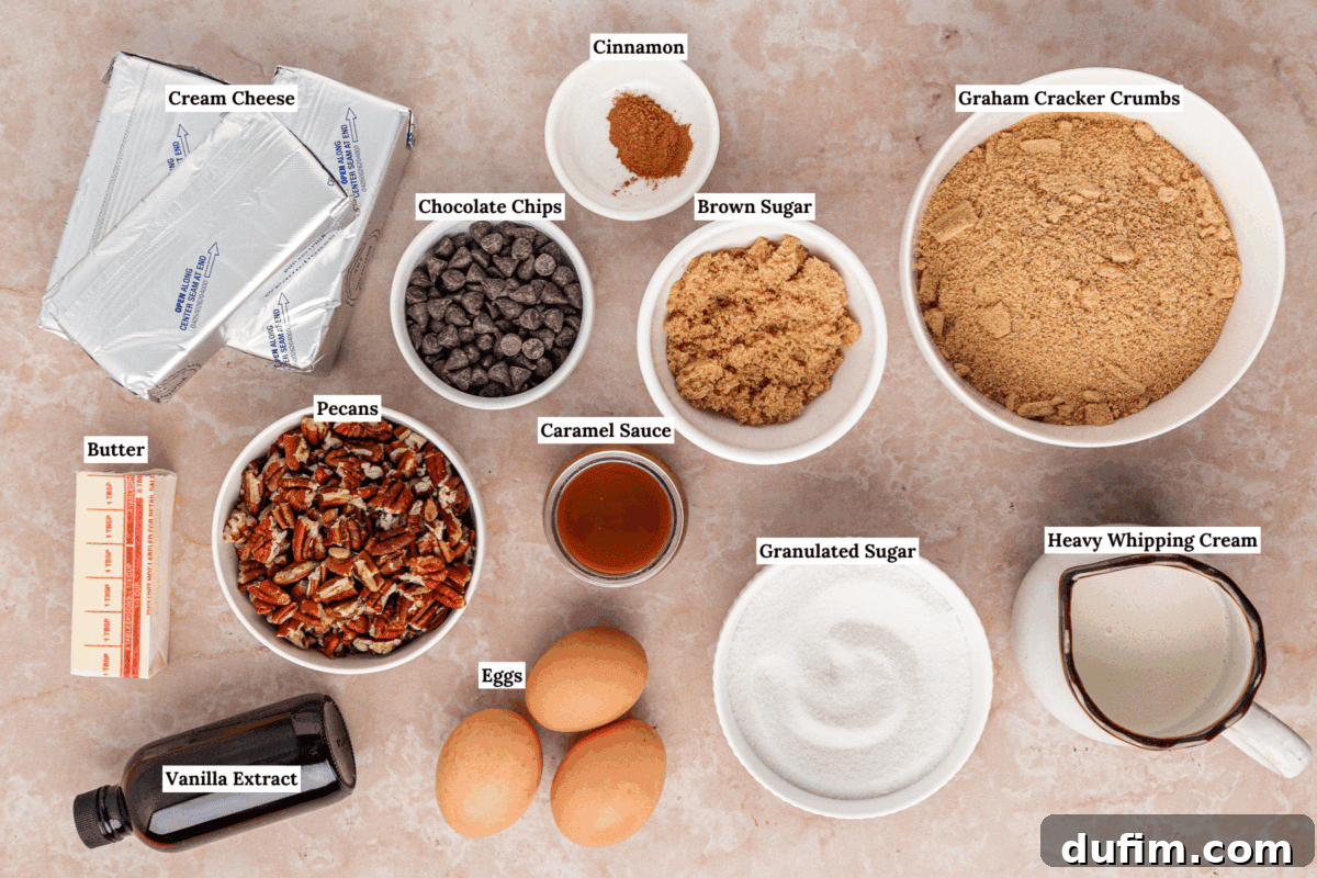 A top-down view of labeled baking ingredients including cream cheese, chocolate chips, pecans, butter, vanilla extract, eggs, cinnamon, caramel sauce, brown sugar, granulated sugar, graham cracker crumbs, and heavy whipping cream.