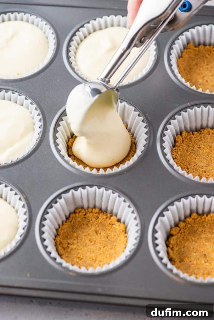 Muffin pan filled with cheesecake batter, ready for baking.