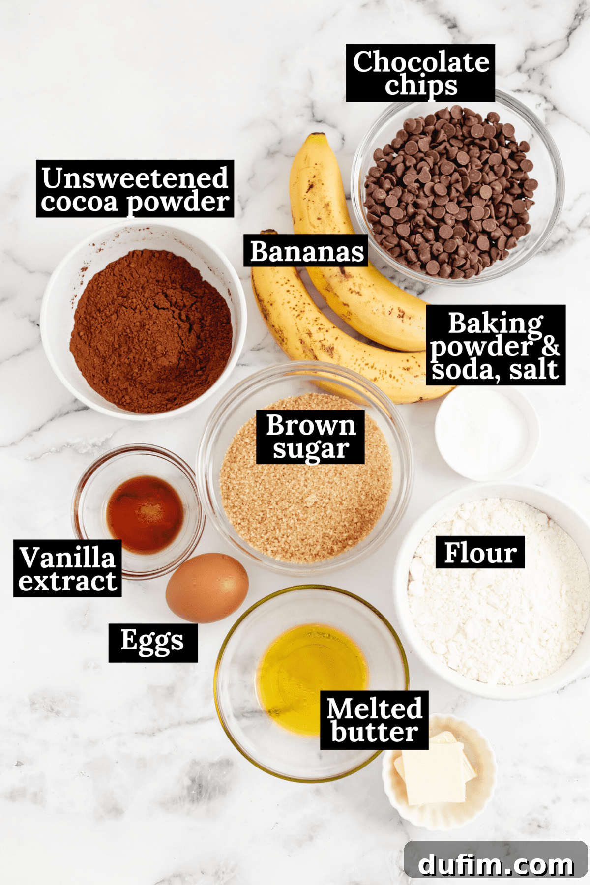 An overhead view showcasing all the essential ingredients for Double Chocolate Banana Bread, neatly arranged and labeled on a countertop, ready for mixing.