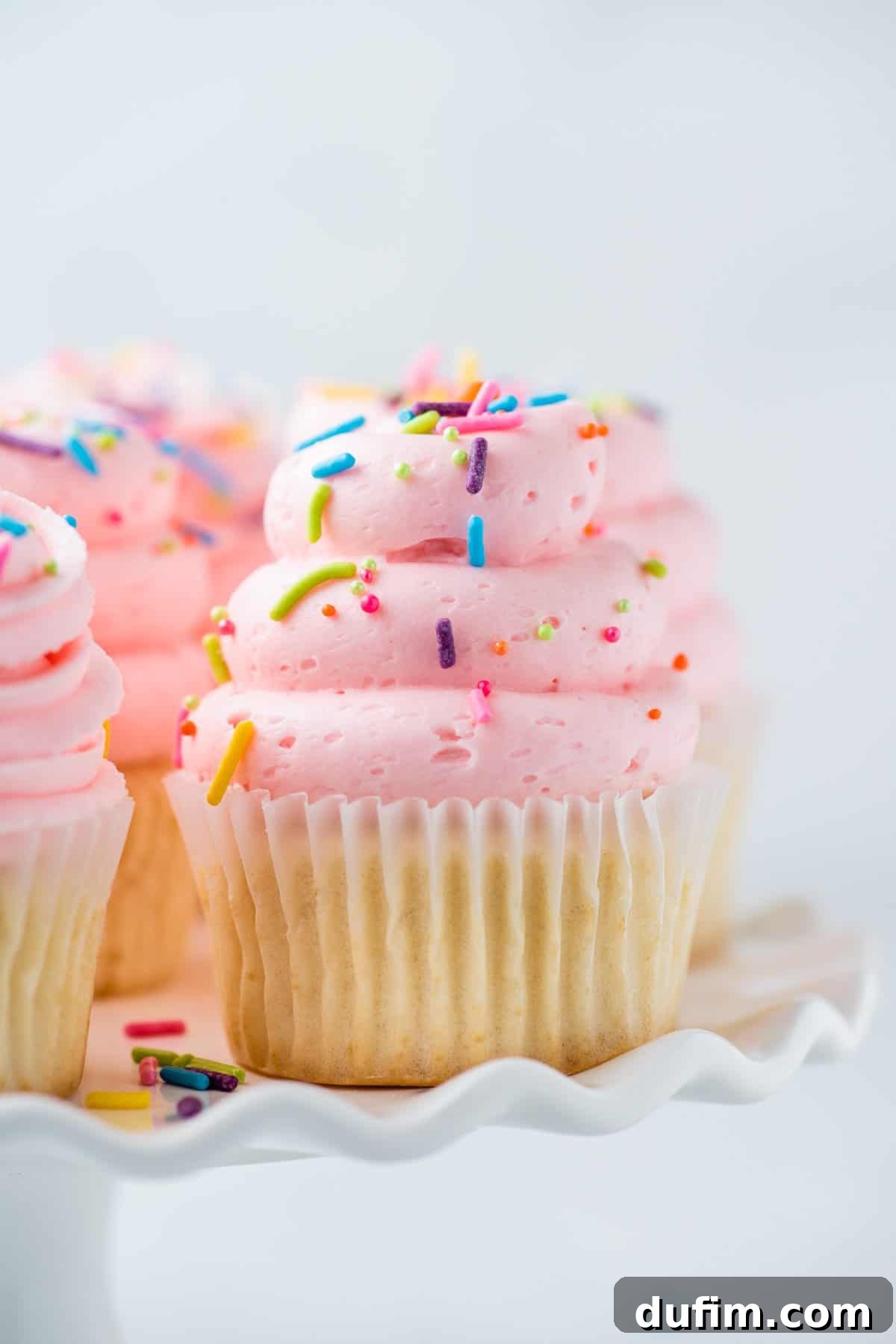 Delightful gluten-free vanilla cupcake awaiting its first bite, perfectly presented on an elegant cake stand.