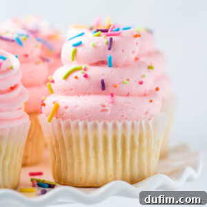 Closeup of gluten-free cupcake topped with pink frosting and sprinkles