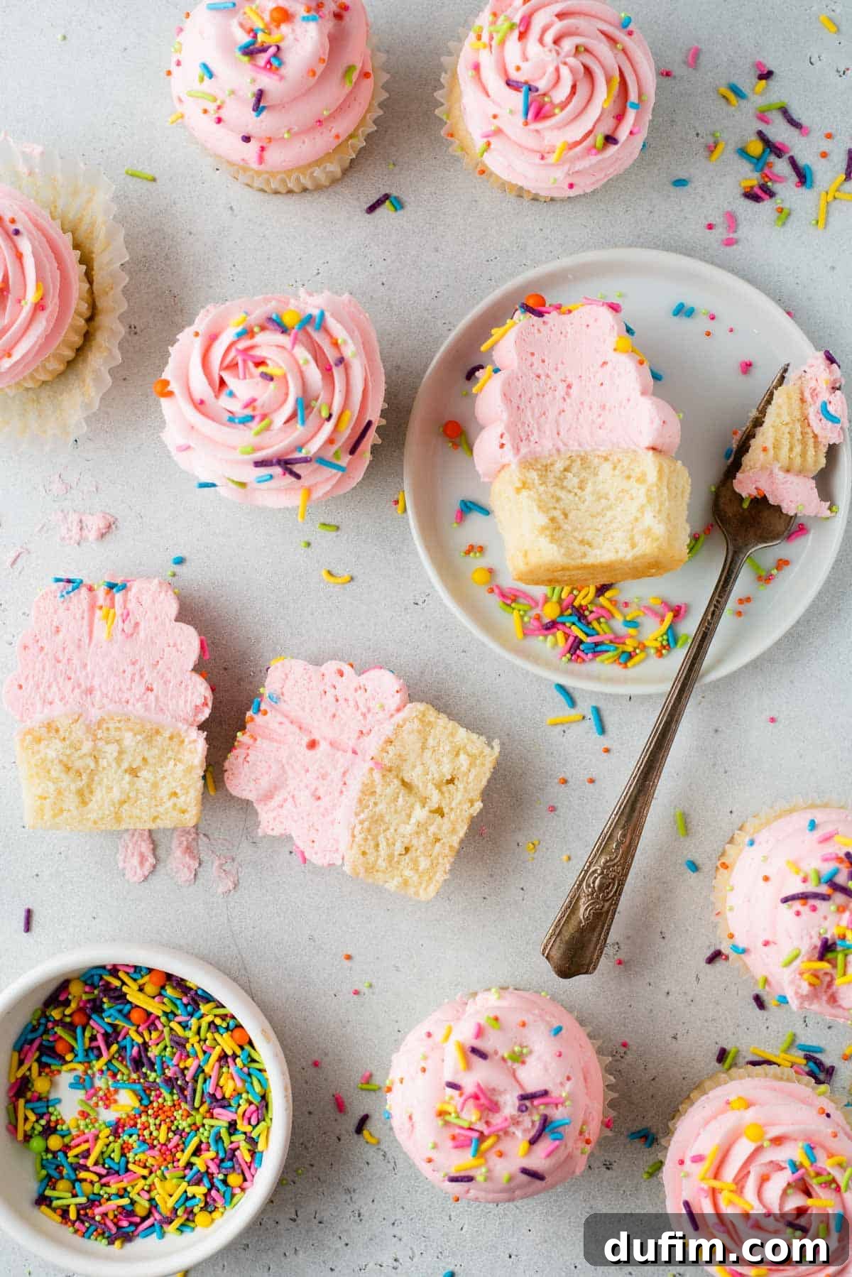 An inviting overhead view of freshly frosted gluten-free cupcakes, artfully arranged on a tabletop with a scattering of festive sprinkles.