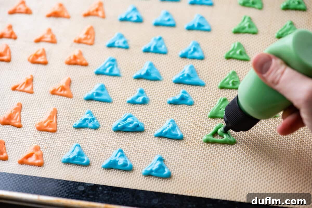 Piping colored almond bark into the shape of dinosaur spikes