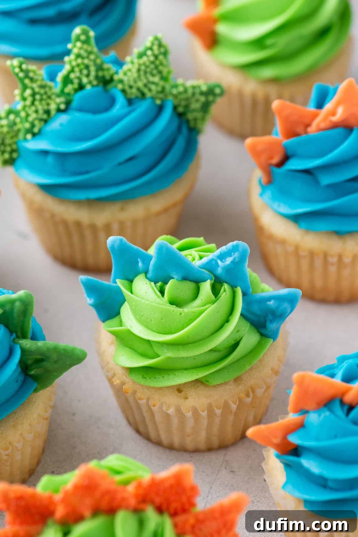 Dinosaur cupcakes with colored frosting and spikes