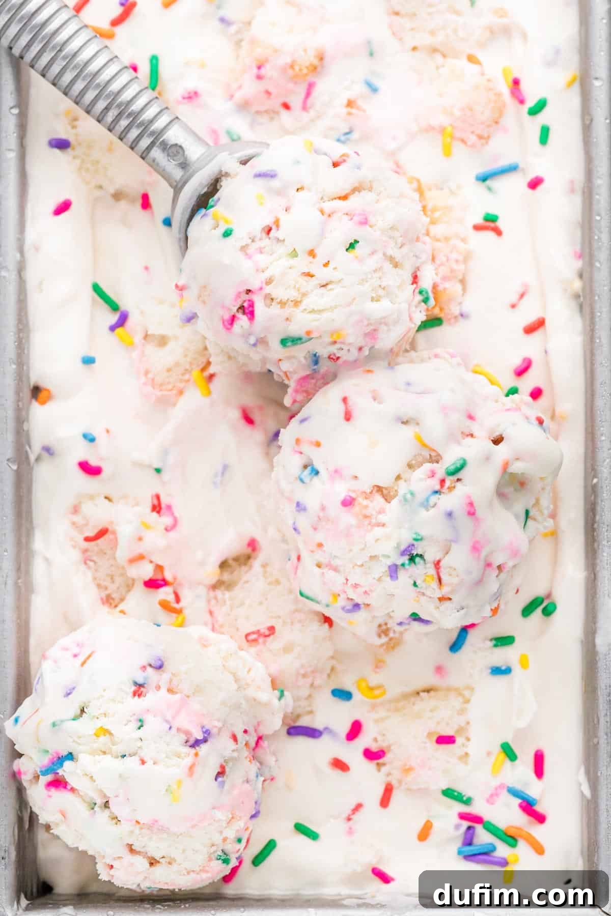 This no-churn Birthday Cake Ice Cream is loaded with colorful sprinkles and cupcakes! So easy to make, and you don't need an ice cream maker! Scoops of birthday cake ice cream in loaf pan, generously topped with sprinkles and cake pieces.