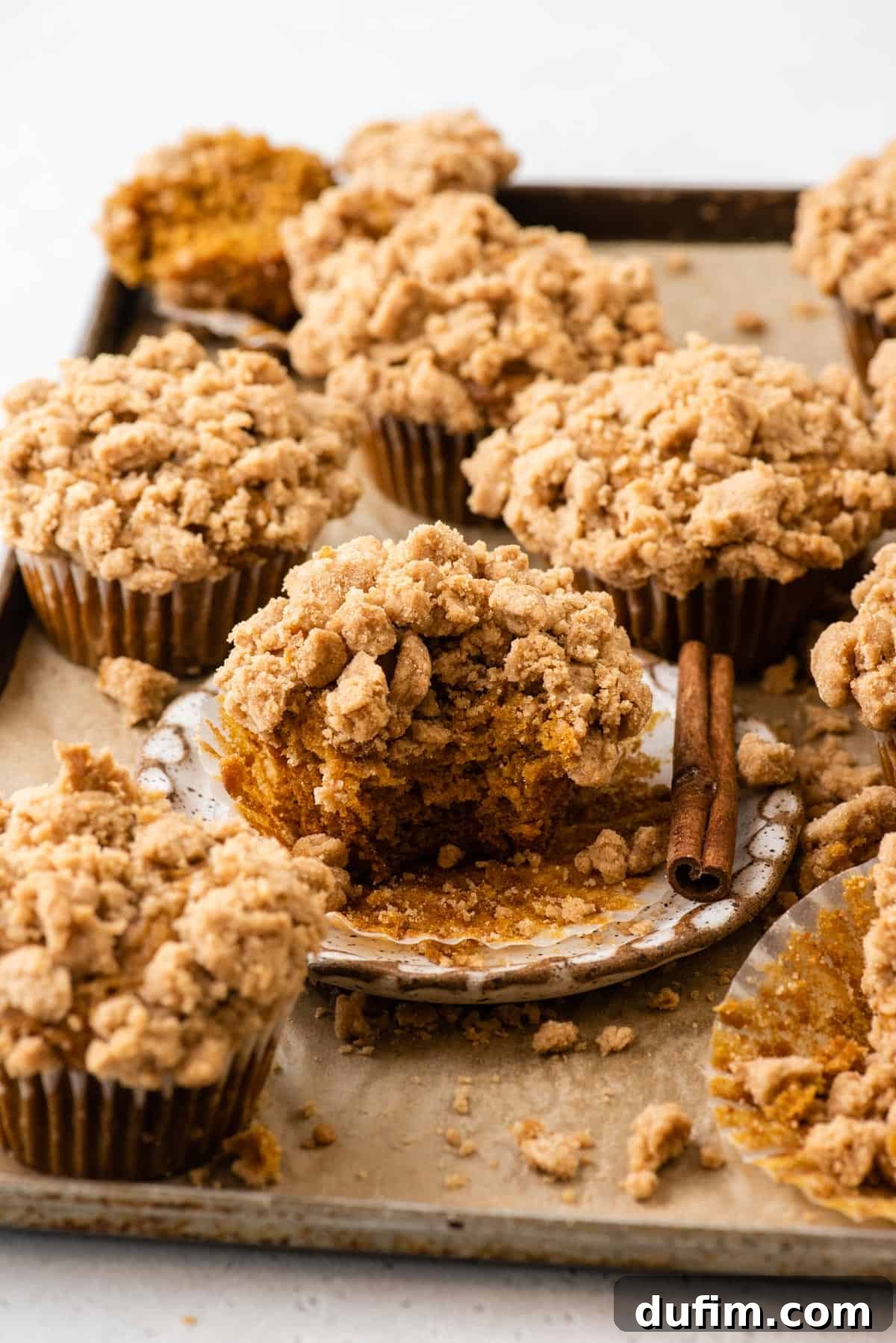 Autumn Spiced Gluten-Free Pumpkin Streusel Muffins 13 pumpkin muffins topped with streusel arranged on baking sheet