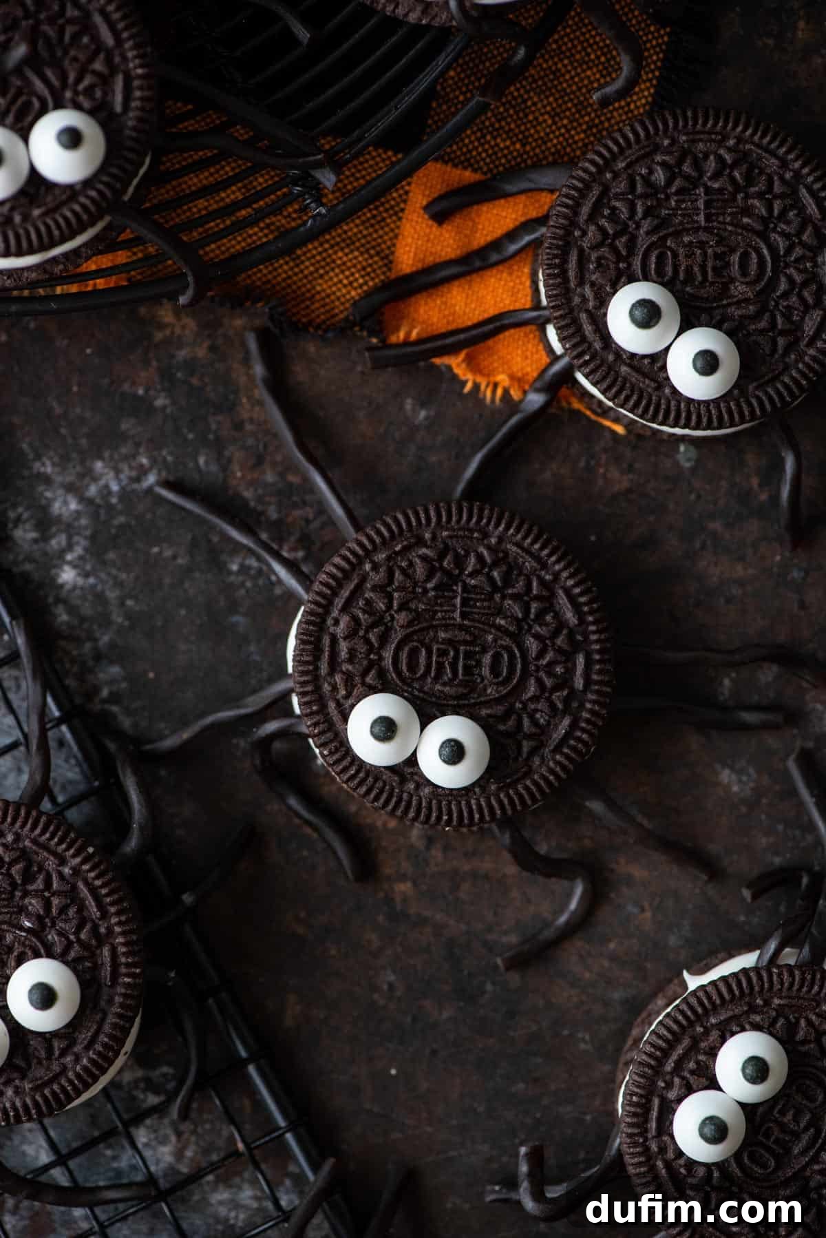 Creative Oreo Spider Ideas Overhead view of several Oreo spiders on a black and orange background, showcasing their delightful appearance.