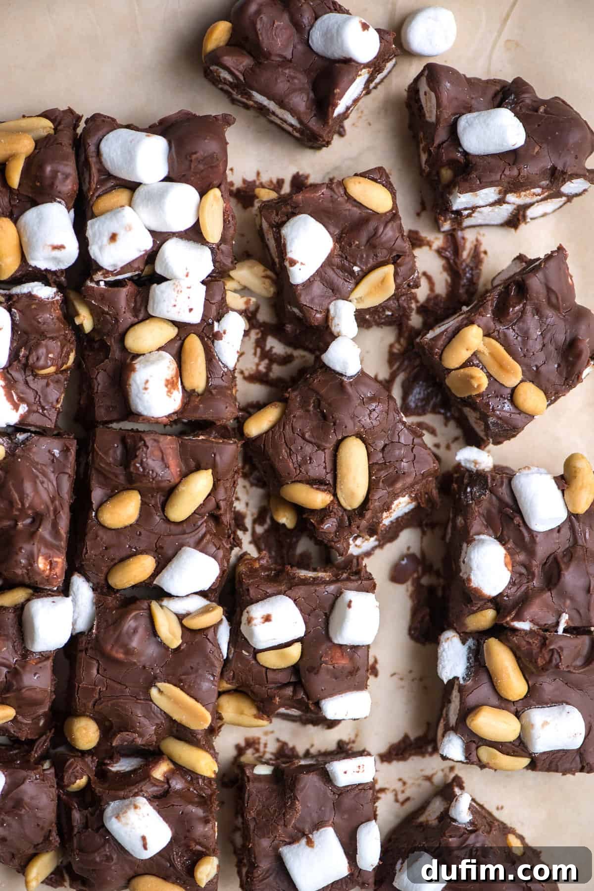 Arranged on brown parchment paper, rich rocky road fudge squares are ready to be served or stored.