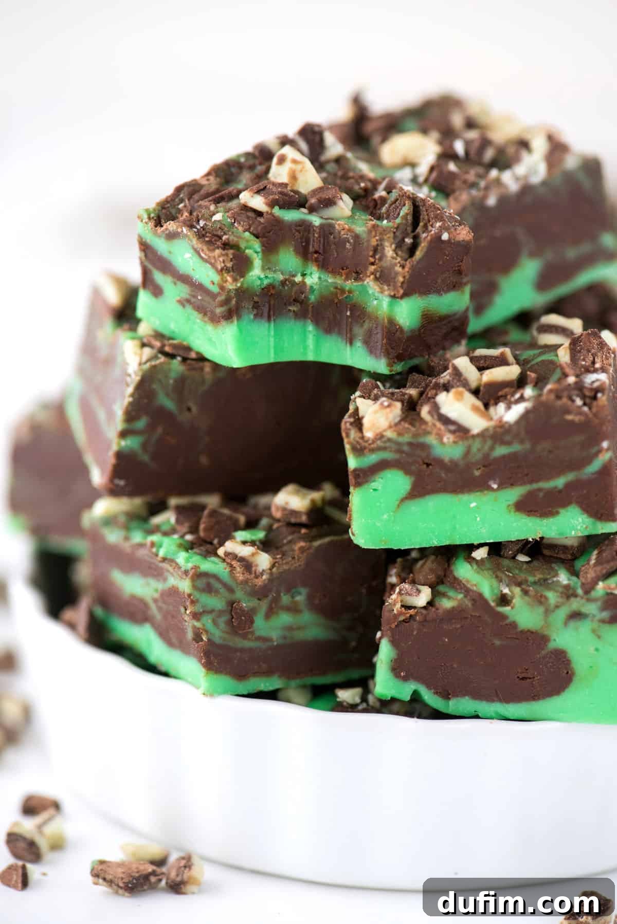 Mint chocolate fudge cut into perfect squares and displayed in an elegant white container.