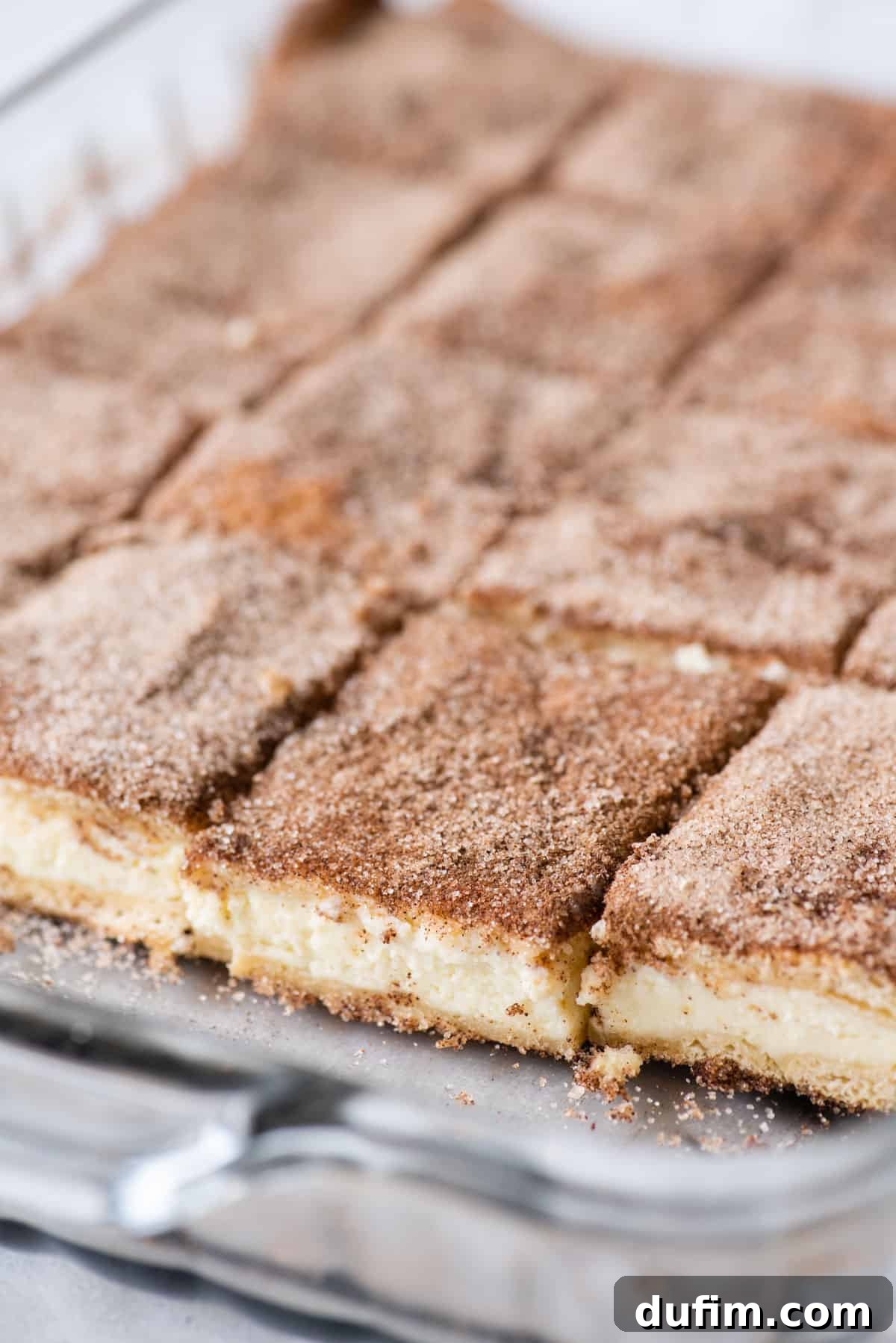 With a buttery, flaky crust, cinnamon sugar topping, and tangy cheesecake filling, this Churro Cheesecake is easy to make & ridiculously good. Angled view of churro cheesecake bars arranged on a platter