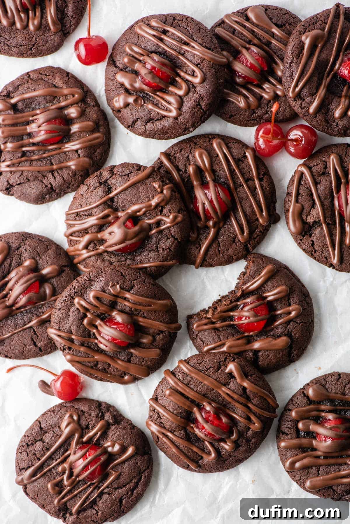 An overhead view of several chocolate cherry cookies placed on a pristine white countertop, ready to be enjoyed.