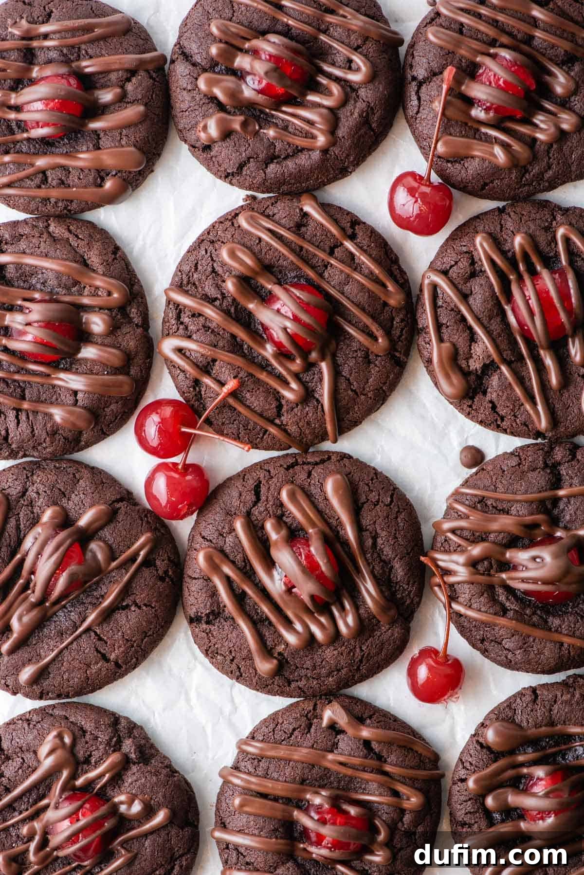 An overhead shot showcasing a platter of perfectly drizzled chocolate cherry cookies, ready to be served.