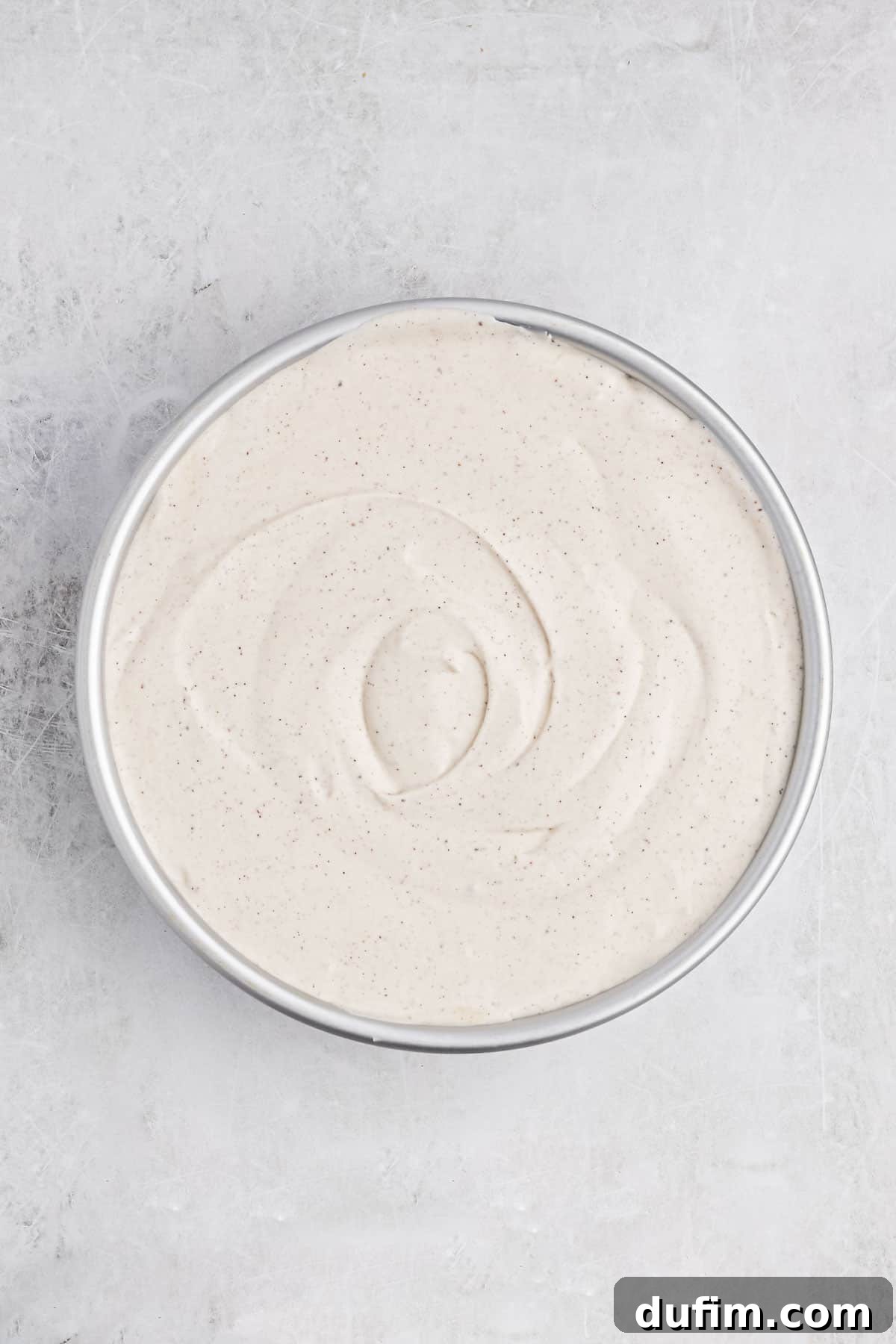 Creamy Homemade Eggnog Ice Cream 4 A loaf pan filled with smooth, unset eggnog ice cream, covered tightly with plastic wrap and ready for freezing.