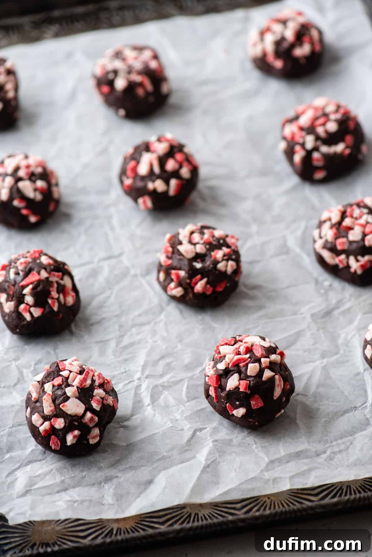 Ready-to-Bake Chocolate Peppermint Cookie Dough on a Tray. Balls of chocolate peppermint cookie dough perfectly arranged on a baking sheet, ready for the oven.
