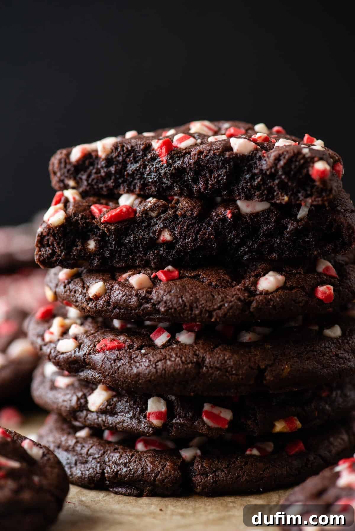 Stacked Chocolate Peppermint Cookies with a Halved Top Cookie. A stack of chocolate peppermint cookies, with the top cookie expertly cut in half to show its soft interior.