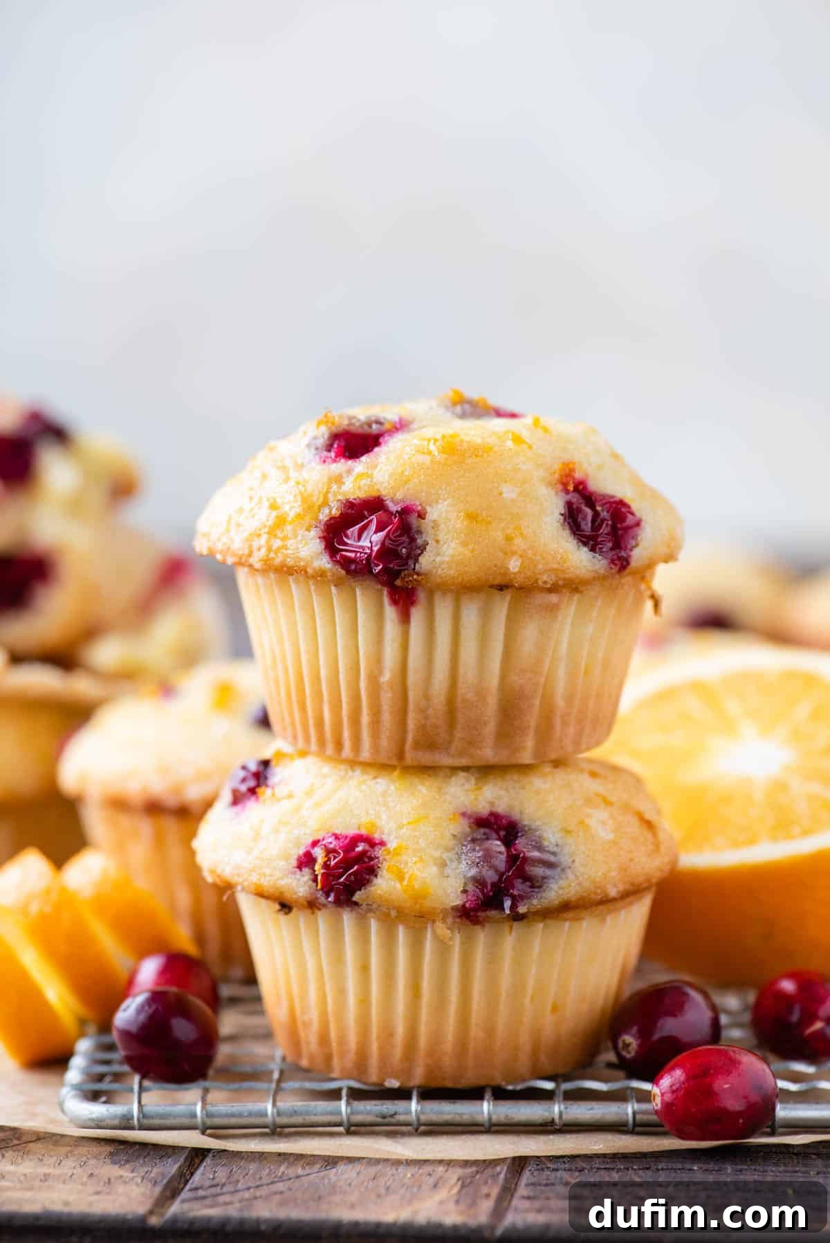Two perfectly baked, stacked orange cranberry muffins, showcasing their tall domes and inviting texture.