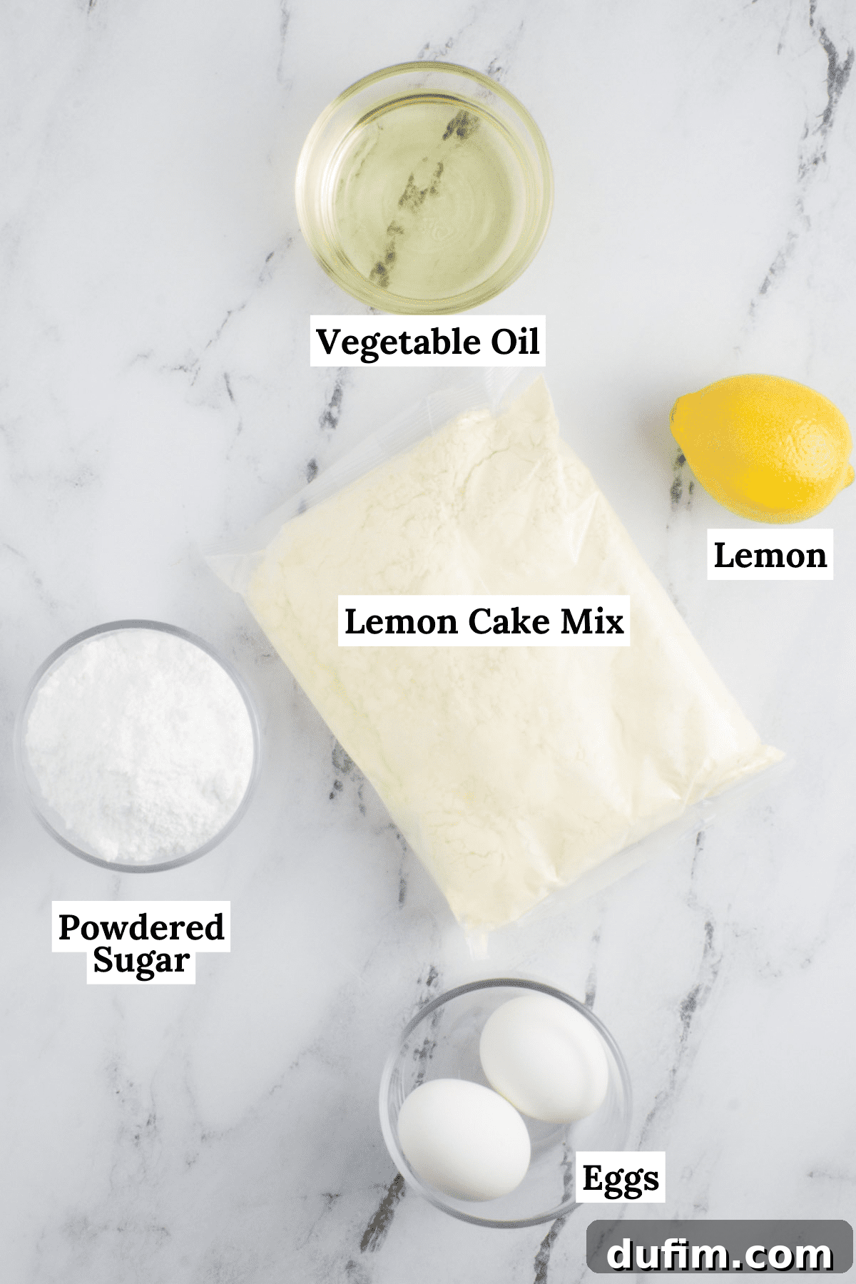 Arrangement of key ingredients for lemon cake mix cookies: a box of lemon cake mix, fresh lemons, eggs, vegetable oil, and powdered sugar, all ready for baking.