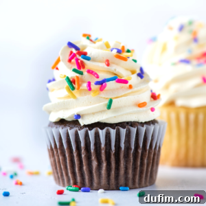 A beautifully frosted chocolate cake slice with sprinkles and a fork, highlighting the smooth texture of the Cool Whip pudding frosting.