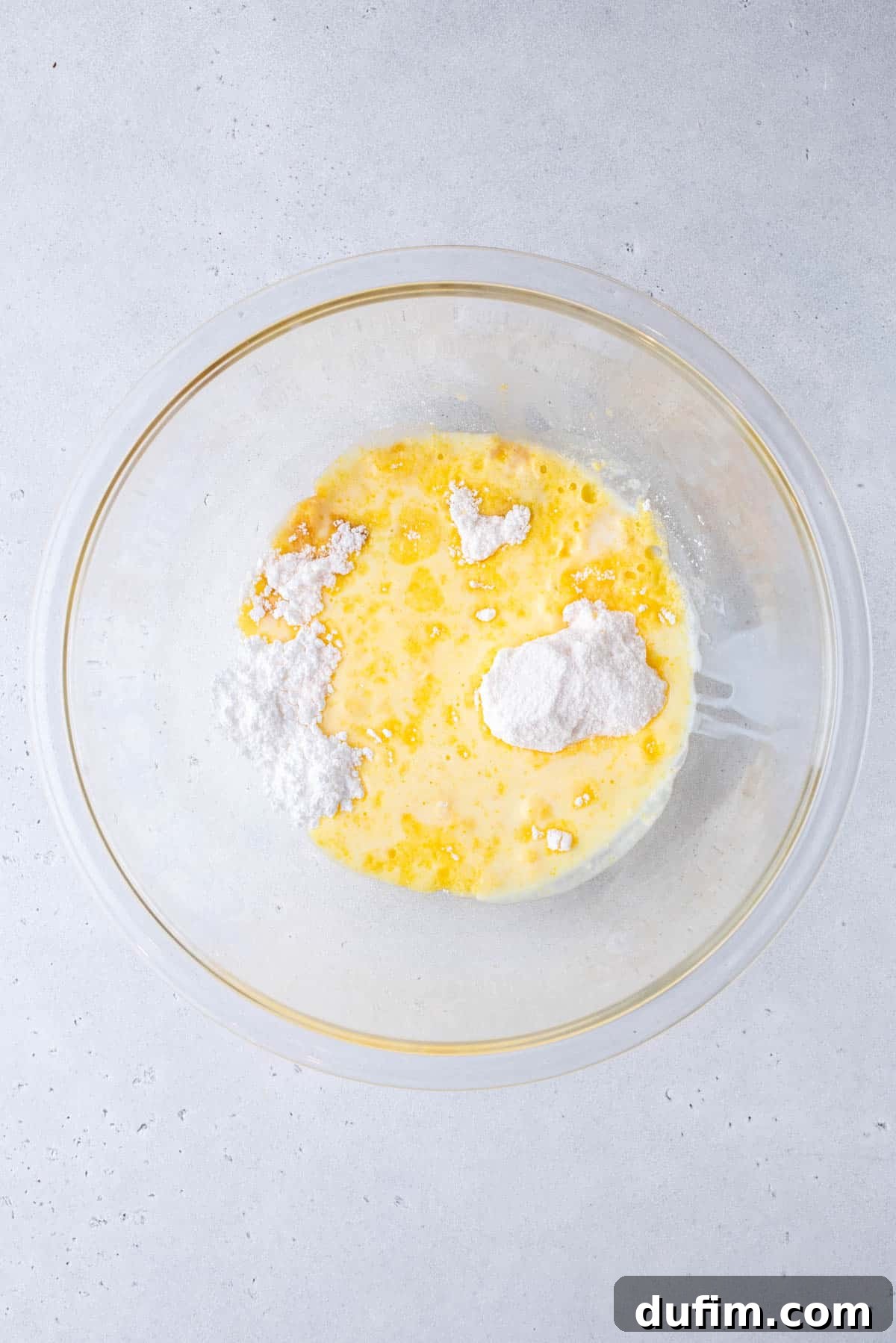 pudding mix, powdered sugar, vanilla extract and milk in a glass mixing bowl