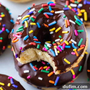 Top view of a freshly glazed chocolate donut with sprinkles, ready to be enjoyed.