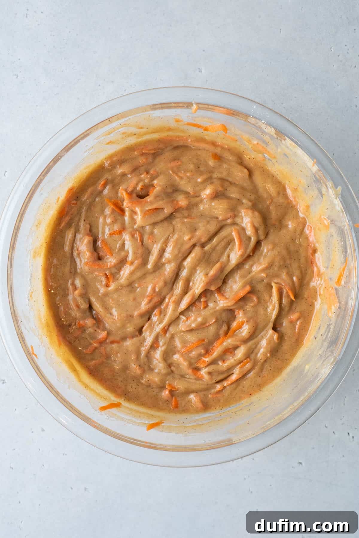 Irresistible Carrot Muffins 5 Batter for carrot cake muffins in a clear glass mixing bowl
