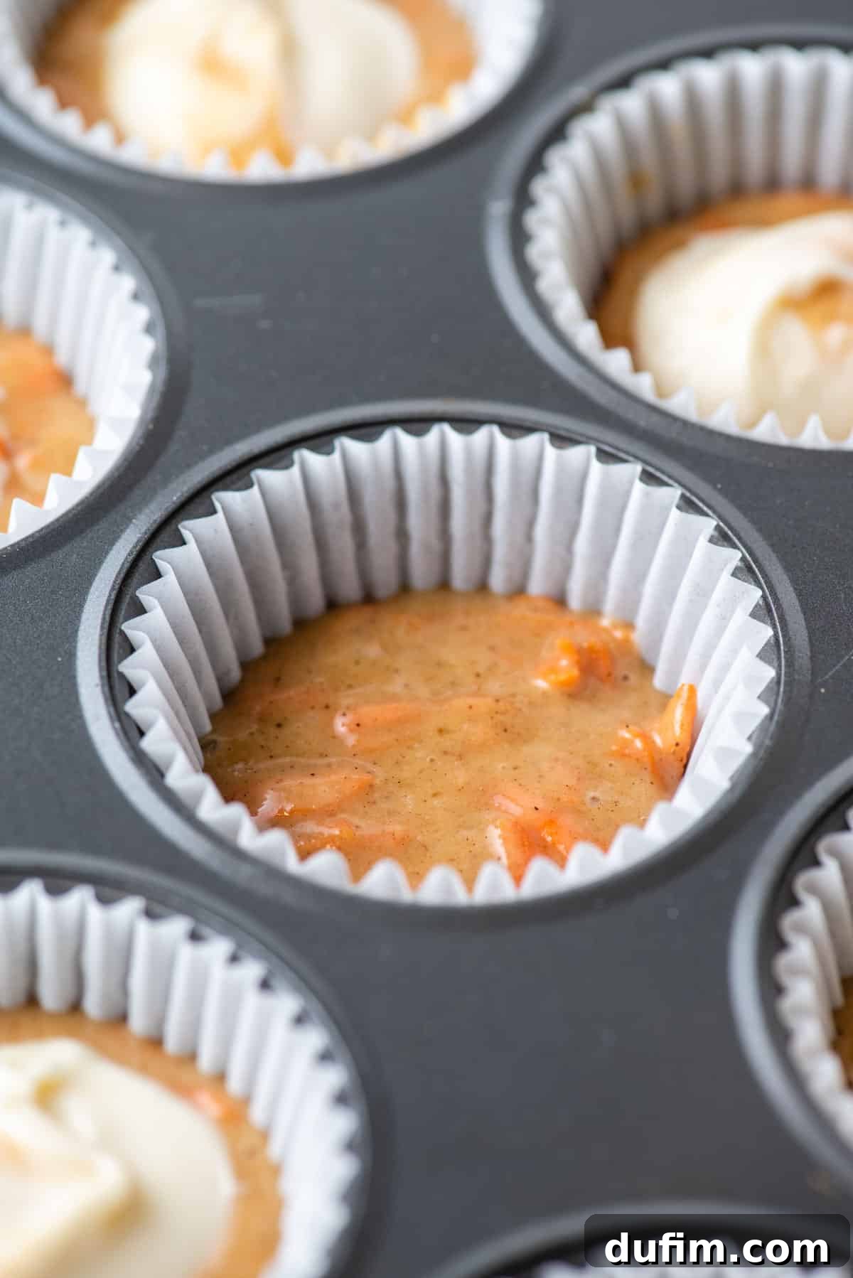 Irresistible Carrot Muffins 6 Carrot cake muffin batter in the bottom of a paper liner in a muffin pan