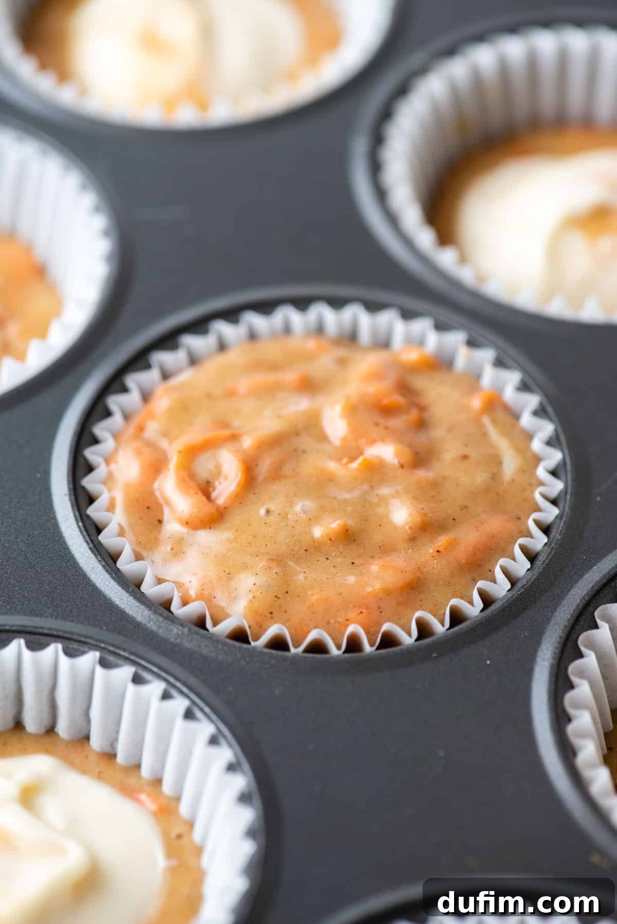 Irresistible Carrot Muffins 9 A muffin pan with a paper liner filled with carrot cake muffin batter