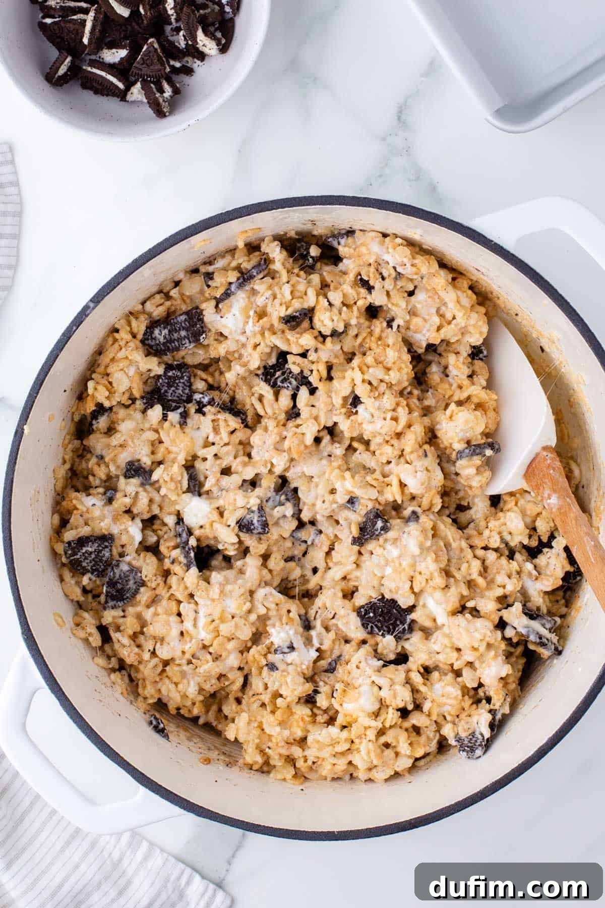 Oreo Dream Krispie Bars 8 oreo rice krispie treats mixture in a white pot with a wood spatula