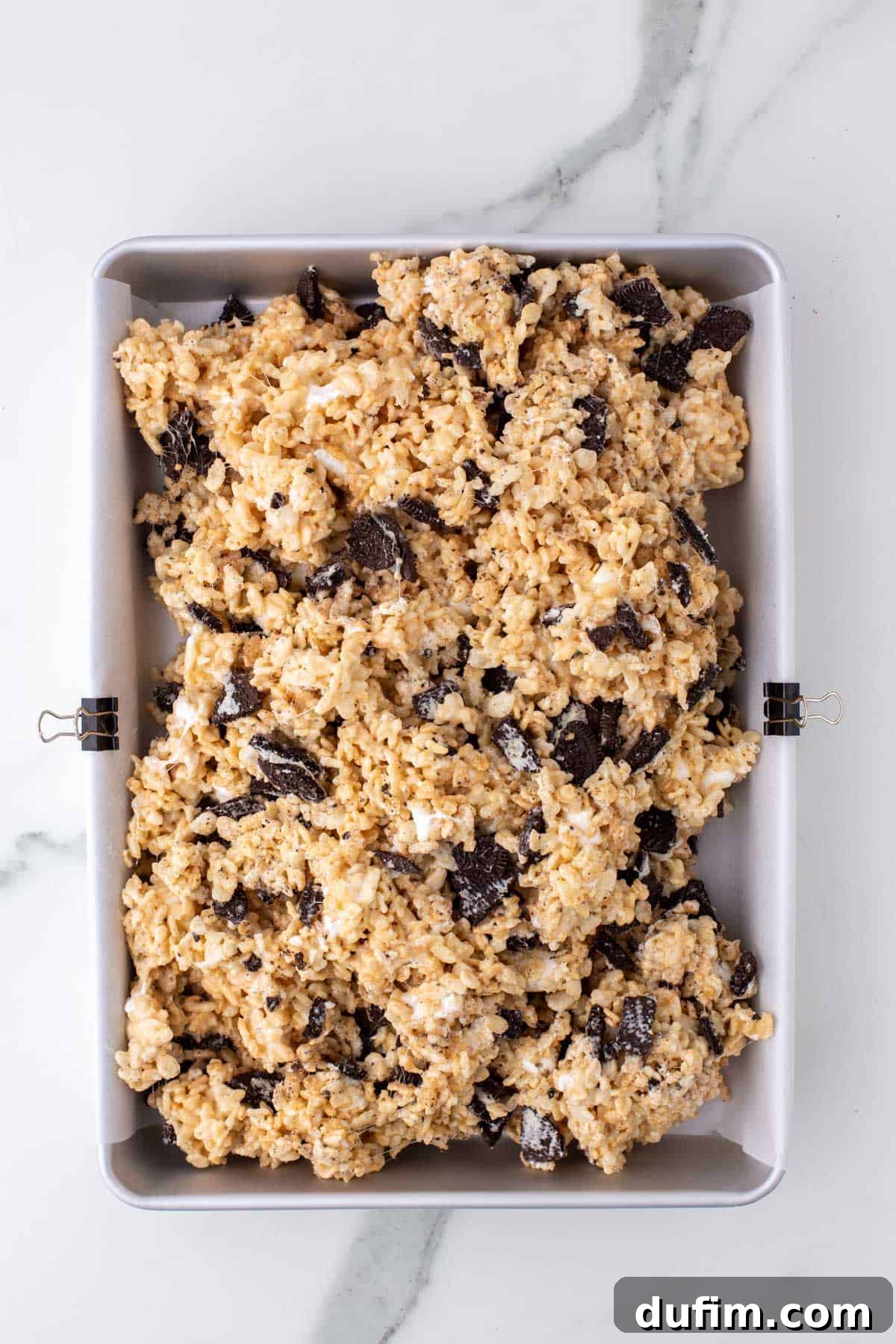 Oreo Dream Krispie Bars 9 oreo rice krispie treats mixture that hasn't been pressed down yet in a large pan