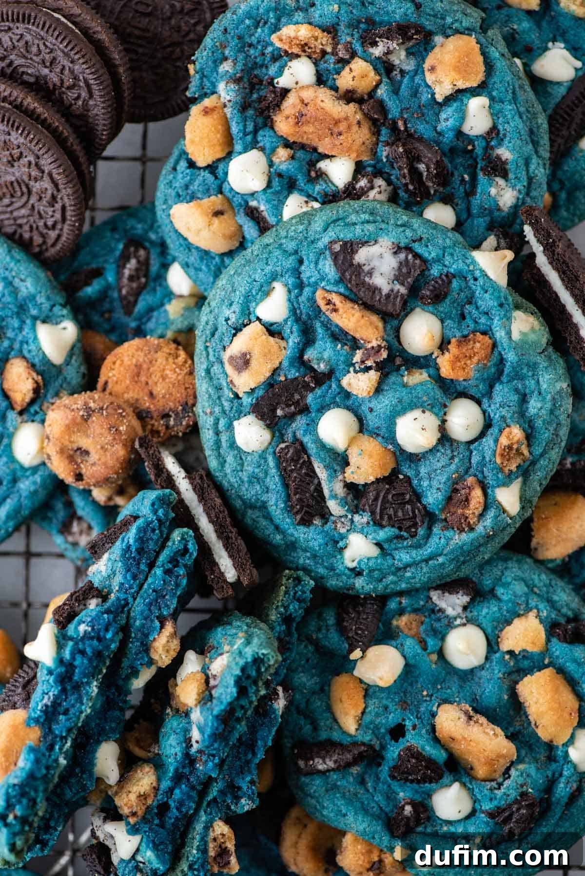 A close-up of a generous pile of vibrant blue Cookie Monster Cookies, showcasing their appealing texture and the visible chunks of Oreos and Chips Ahoy cookies mixed in.