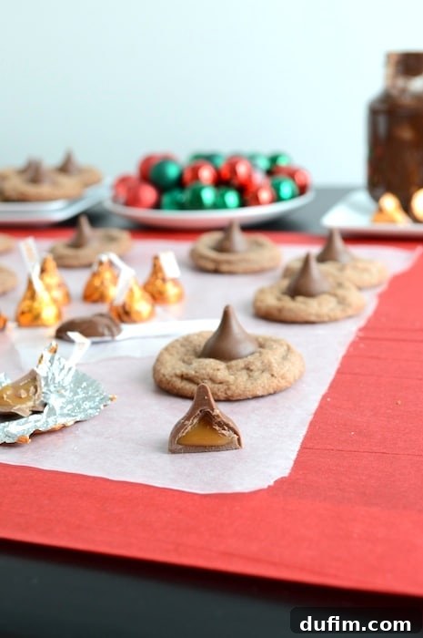Nutella Caramel Delights 4 Several Nutella Caramel Kisses cookies cooling on a wire rack, with unwrapped caramel kisses scattered around