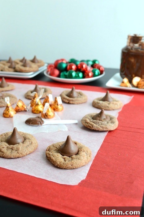 Nutella Caramel Delights 6 A festive spread of Nutella Caramel Kisses cookies on a plate, surrounded by holiday decorations, highlighting their appeal for celebrations