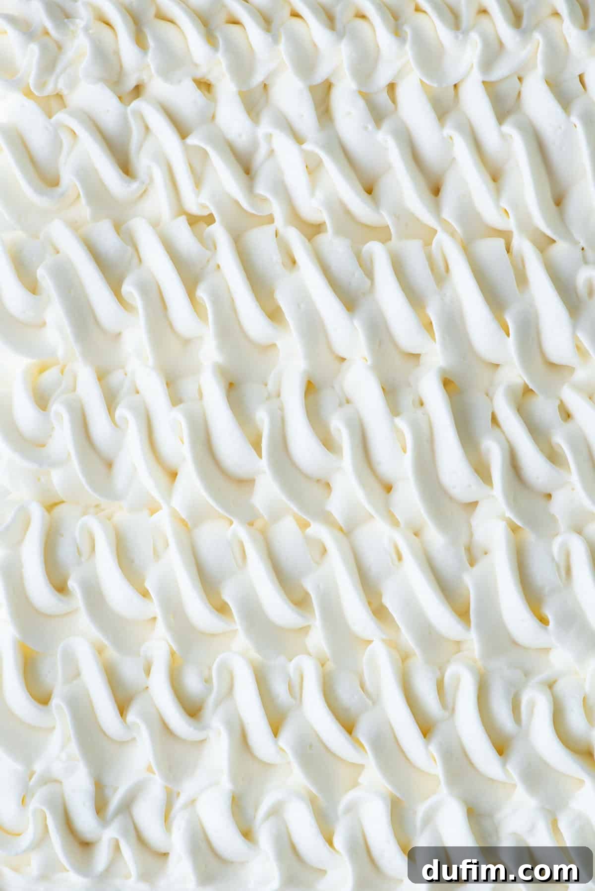 Stabilized whipped cream elegantly piped into a decorative pattern, highlighting its ability to hold intricate shapes.