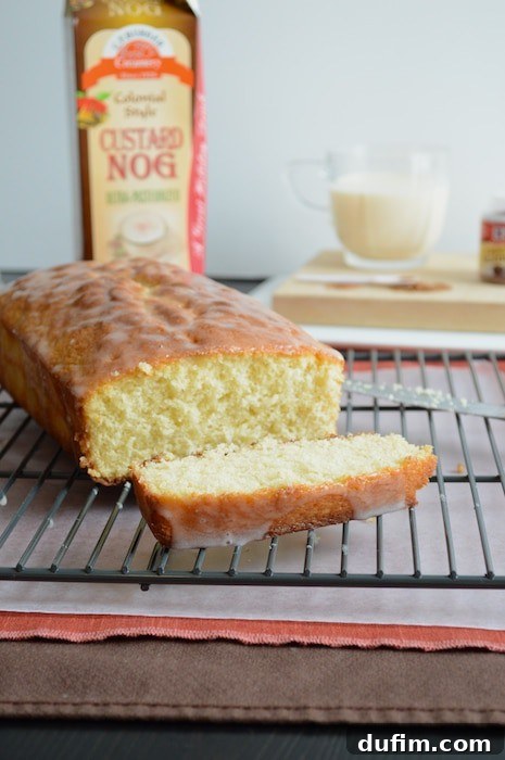 Close-up of a slice of Whipped Eggnog Loaf Cake revealing its moist, light interior.