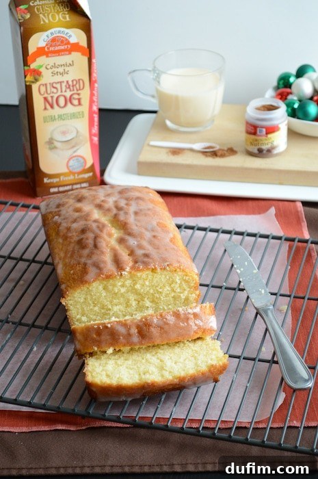 A slice of Whipped Eggnog Loaf Cake garnished with festive sprinkles, perfect for a holiday spread.