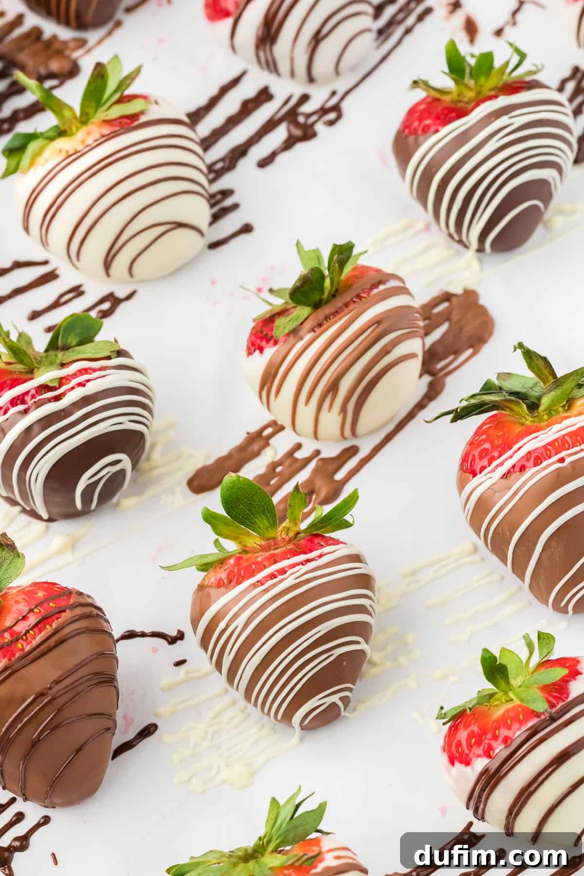 Irresistible Chocolate Dipped Strawberries 4 Rows of beautifully arranged chocolate covered strawberries, alternating between white chocolate with a dark chocolate drizzle and milk chocolate with white and dark chocolate drizzles.
