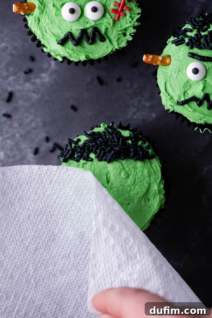 A cupcake with green frosting and black sprinkle hair, ready for the next facial features.