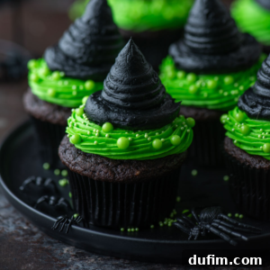 witch hat cup cakes arranged on a black plate, showcasing the green base and black hat frosting.