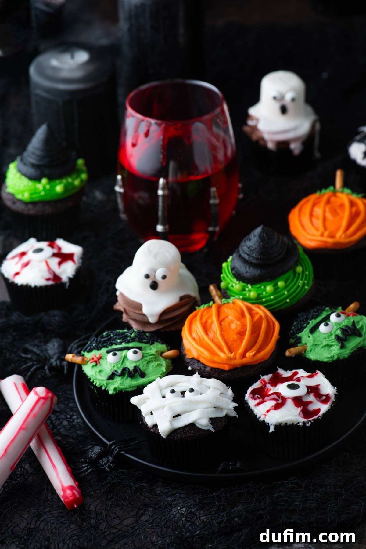 Ghoulishly Good Cupcakes 21 A festive assortment of Halloween cupcakes, including delightful ghost, intense eyeball, classic mummy, charming pumpkin, elegant witch hat, and playful spider designs, all presented on a tiered stand.