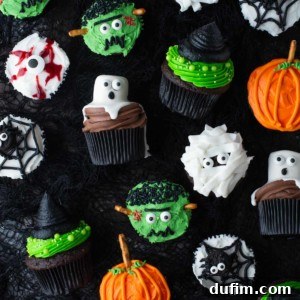 An appetizing assortment of Halloween cupcakes, featuring ghost, eyeball, mummy, pumpkin, witch hat, and spider designs, perfect for any festive occasion.