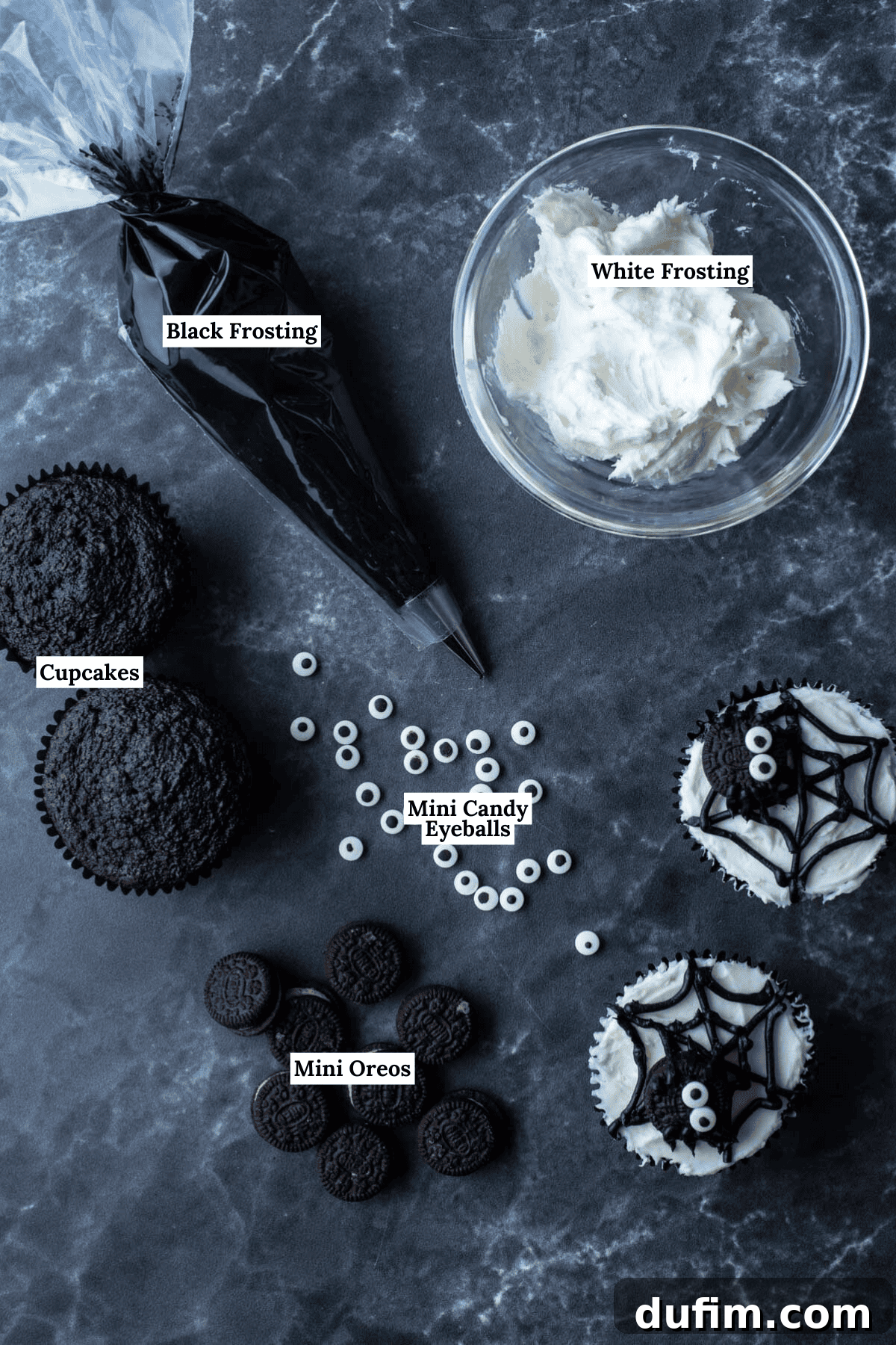 Essential ingredients for spider web cupcakes, including smooth white frosting, dark black frosting, baked chocolate cupcakes, mini candy eyeballs, and mini Oreos, neatly arranged.