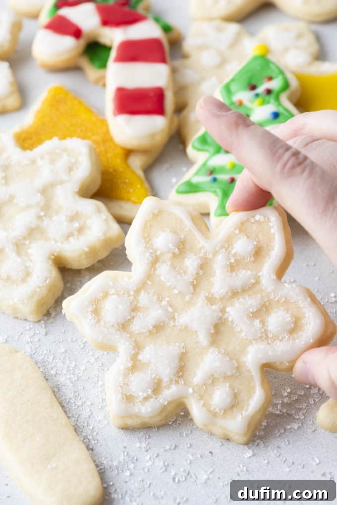 Royal icing on a snowflake-shaped cookie with sugar sprinkled on top.