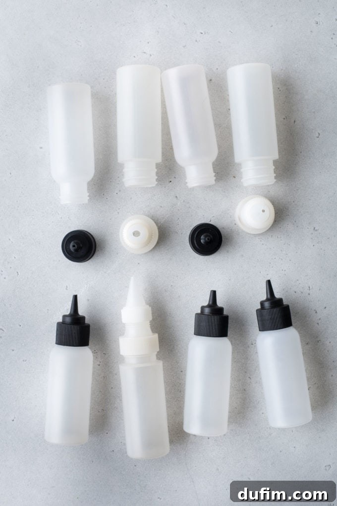 Squeeze bottles with lids, some white and some black, lying on their sides on a countertop.
