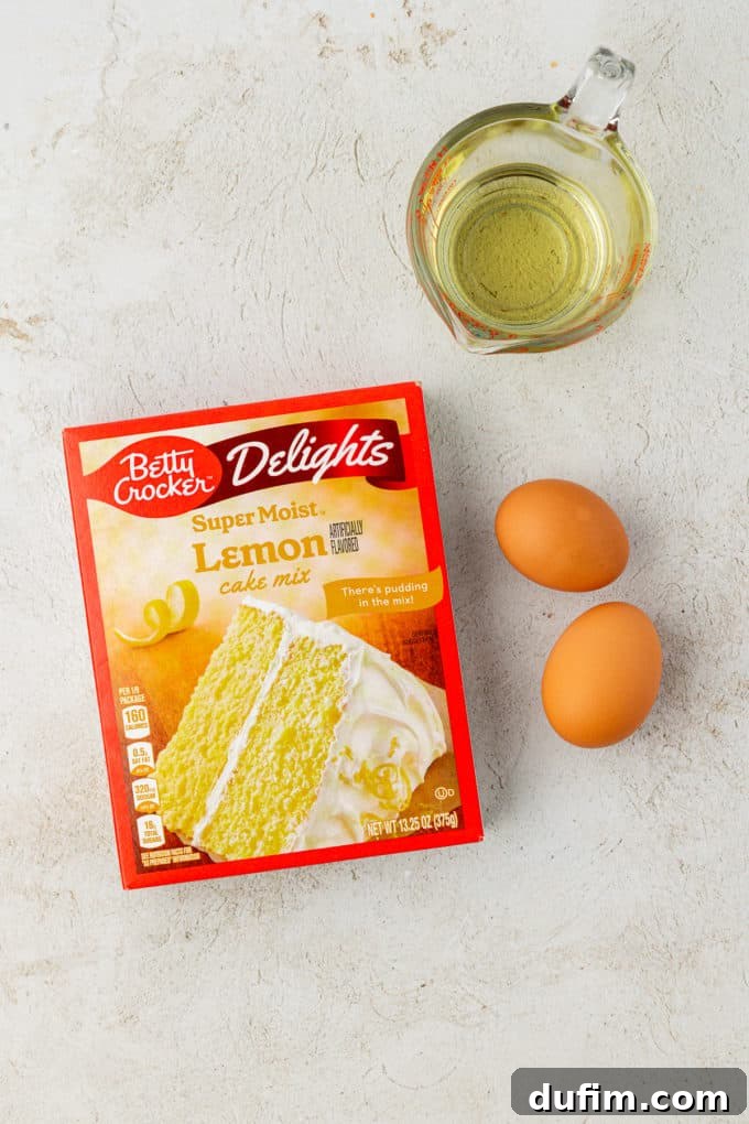 Ingredients for bright lemon cake mix cookies: a box of lemon cake mix, two fresh eggs, and vegetable oil, arranged neatly on a surface, ready for mixing and baking.
