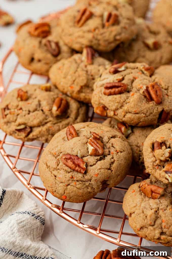 Freshly baked carrot cake mix cookies, showcasing their golden-brown edges and soft centers, possibly with pecans visible for texture and flavor.