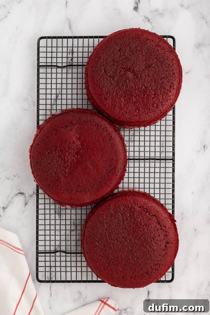 Homemade Red Velvet Cake Perfection 14 Three perfectly baked red velvet cake layers resting on a wire rack, cooling evenly after being removed from their pans.