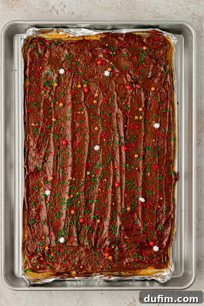 The other half of the sheet pan showcasing Christmas Crack candy, brightly covered with festive holiday sprinkles.