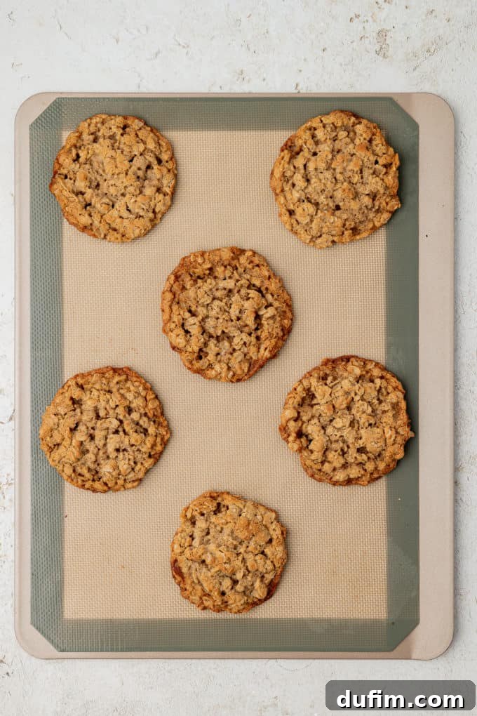 baked oatmeal cookies on a baking sheet lined with a silicone baking mat