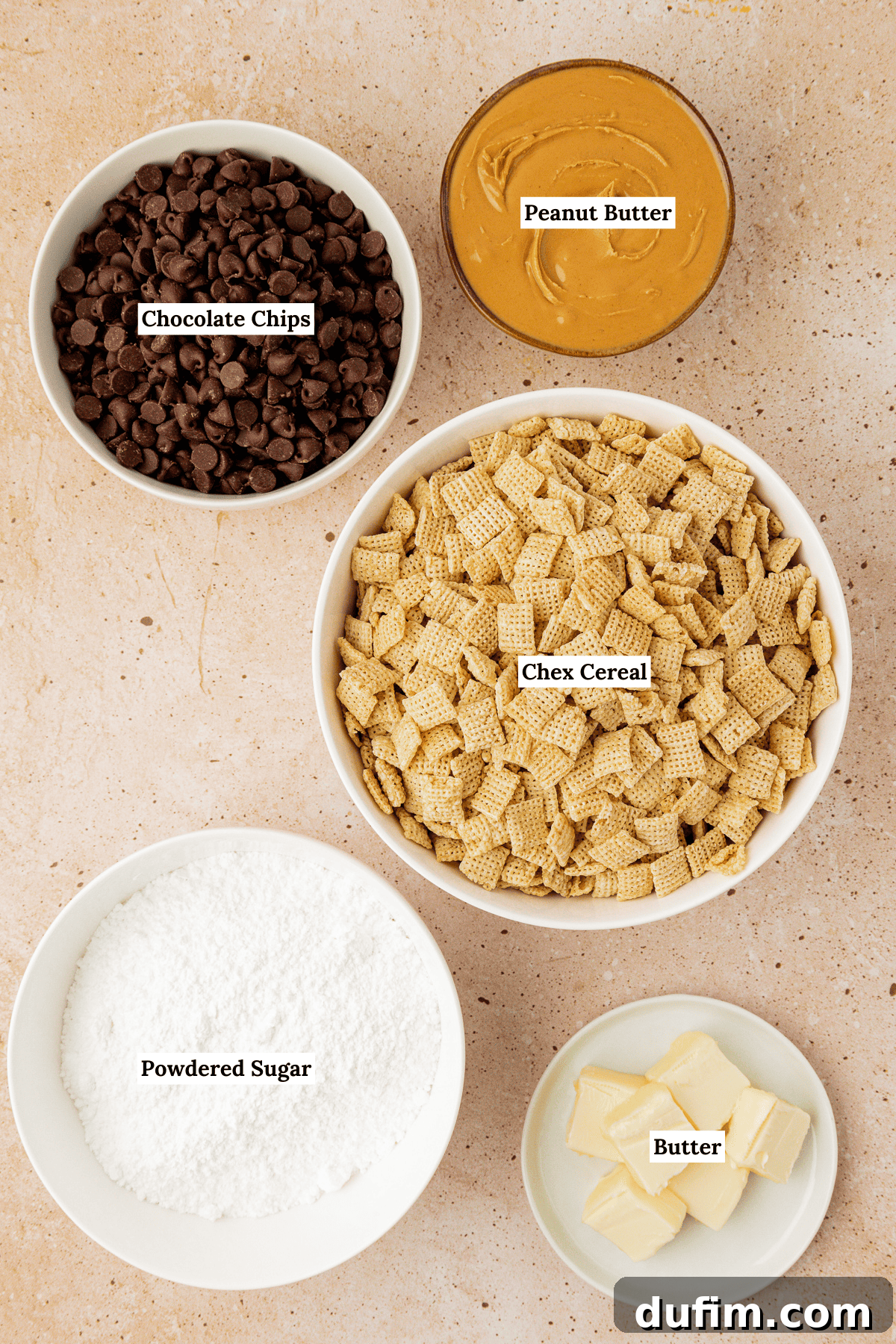 Overhead view of puppy chow ingredients including chex cereal, powdered sugar, chocolate chips, peanut butter and butter