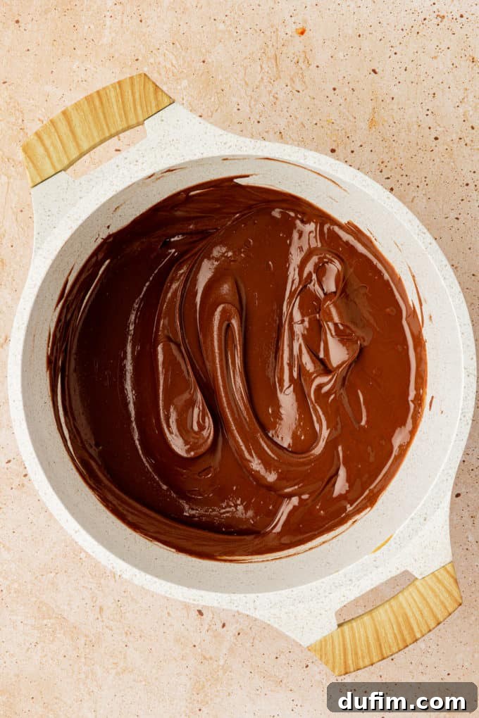 a melted mixture of chocolate chips, peanut butter and butter in a white pot